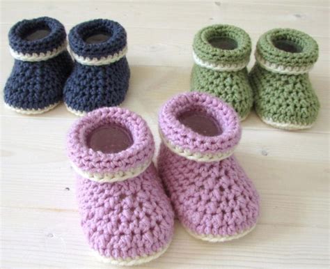 Several Crocheted Baby Booties Sitting On Top Of A Wooden Floor Next To