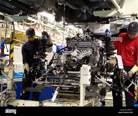 Workers At Toyota Final Assembly Production Line Prepare The Engine For