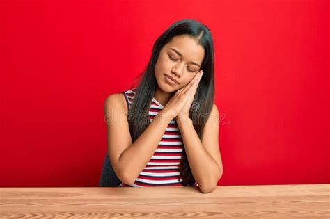 Beautiful Hispanic Woman Wearing Casual Clothes Sitting On The Table