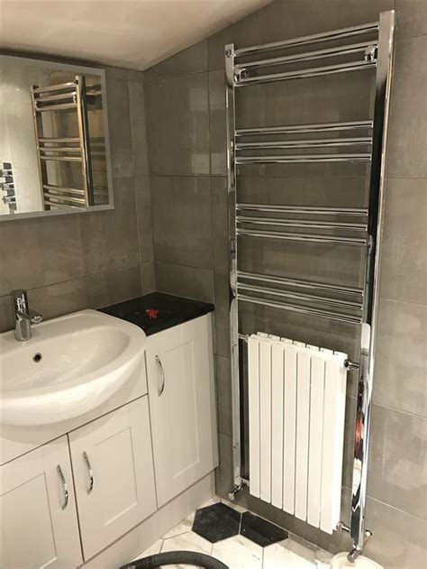 A Bathroom With A Sink Mirror And Radiator