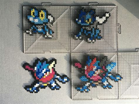 Four Pixel Art Magnets Sitting On Top Of A White Table Next To Each Other