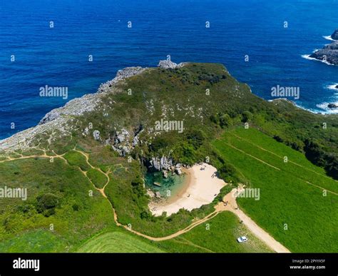 Aerial View On Small Playa De Gulpiyuri Flooded Sinkhole With Inland