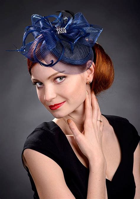 A Woman With Red Hair Wearing A Blue Hat And Black Dress Posing For The Camera