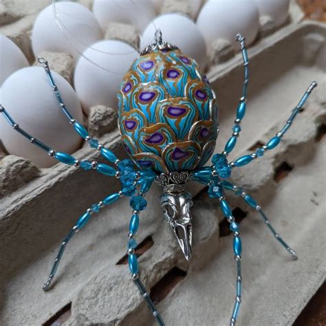 A Blue And White Spider Sitting On Top Of An Egg Carton Filled With Eggs