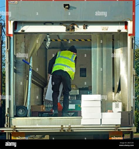 Lorry Driver In High Vis Jacket Inside Back Of His Delivery Truck