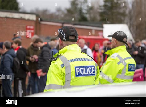 Rear View Of West Mercia Police Officers Watching Queuing Football Fans