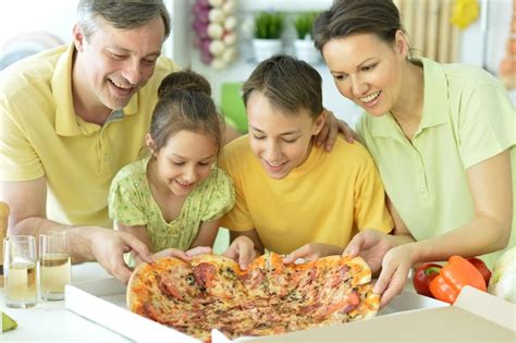 Retrato De Familia Feliz Comiendo Pizza Juntos Foto Premium