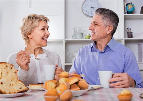 Mature Couple Have An Afternoon Snack With Fresh Muffins And Cake Stock Photo Image Of