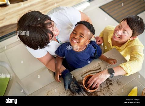 Portrait Happy Lesbian Couple And Son Digging In Dirt In Flowerpot Stock Photo Alamy