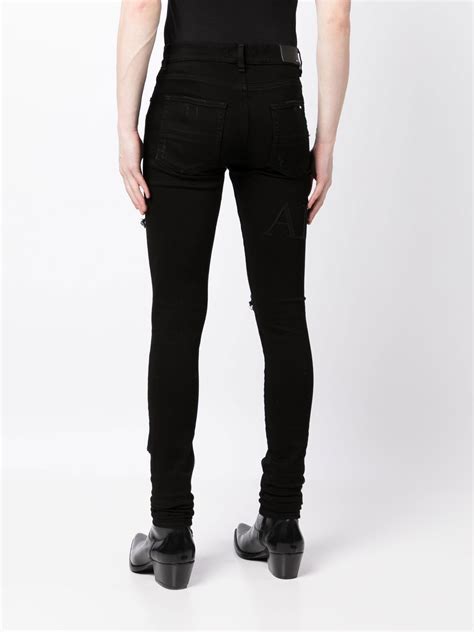 Amiri Ripped Knee Logo Print Skinny Jeans Farfetch