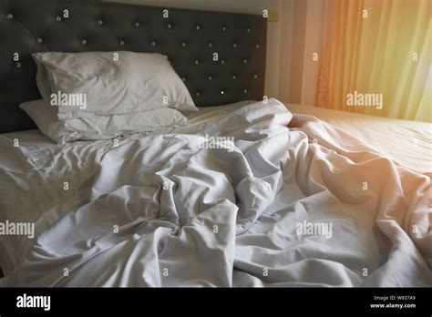 Unmade Bed Sheet Of The Crease And Pillow White Blanket In The Bedroom