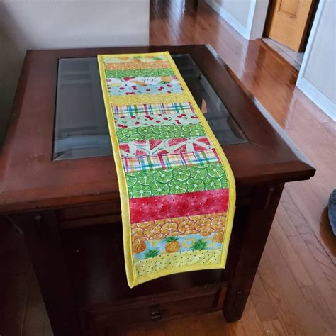 A Wooden Table Topped With A Yellow And Red Runner