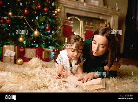 Woman And He Daughter Lying On The Floor And Reading Book Stock Photo