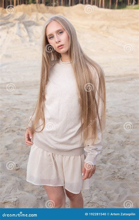 Attractive Caucasian Girl With Long Hair And Nude Makeup Posing Outdoors On Sand Stock Photo