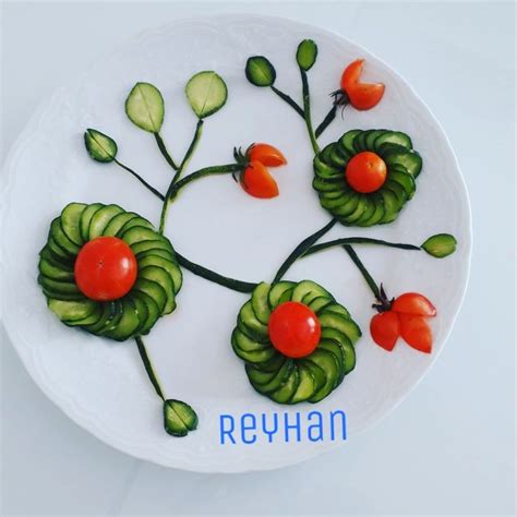 A White Plate Topped With Tomatoes And Cucumbers On Top Of Green Leafy