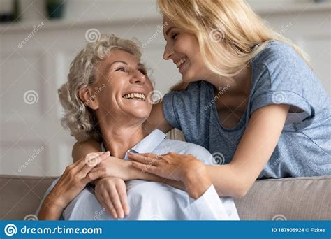 Grown Up Daughter Hugging Elderly Mother Feeling Love Showing Care