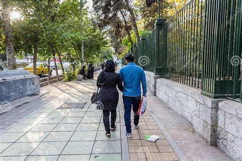 A Pair Of Iranian Couple Holding Hands And Walking In The Street Of