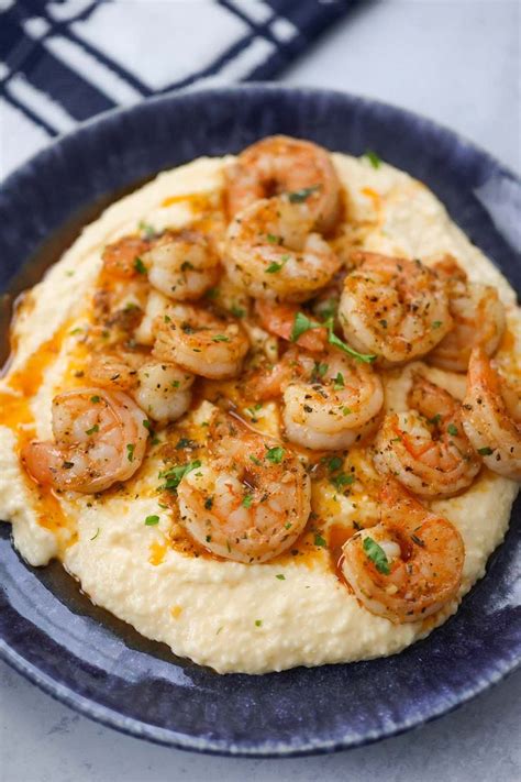 A Blue Plate Topped With Mashed Potatoes And Shrimp