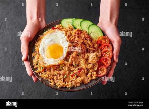 Nasi Goreng Indonesian Chicken Fried Rice On Black Plate In Female
