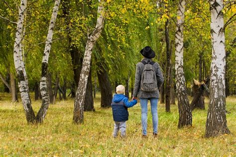 Premium Photo Mom And Son Are Walking In The Autumn Forest