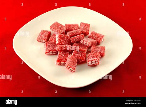 Strawberry Gummy Brick Candy Coated In Sour Sugar On White Plate On Red