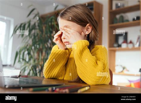 Tired Girl Rubbing Eyes While Sitting In Front Of Laptop At Home Stock