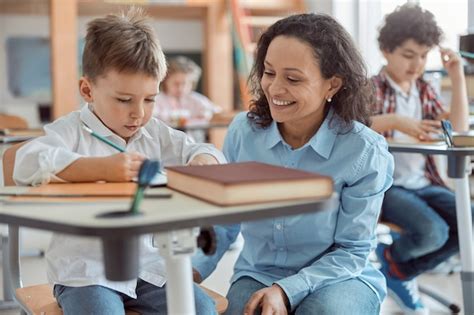 Professora Est Ajudando Um Menino Nas Aulas Do Ensino Fundamental