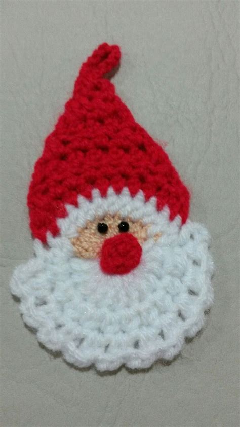 A Crocheted Santa Clause Hat With A Red Nose And White Beard On It