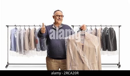Mature Man Collecting Suit From Dry Cleaners And Gesturing Thumbs Up