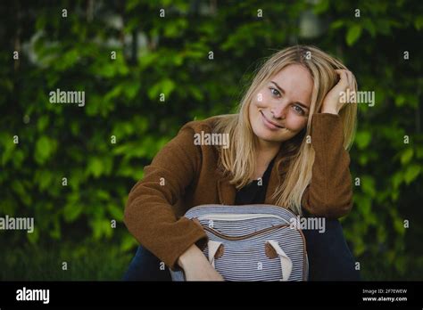 Jeune fille blonde hipster seductevly regardant et souriant à un tout en soutenant son menton