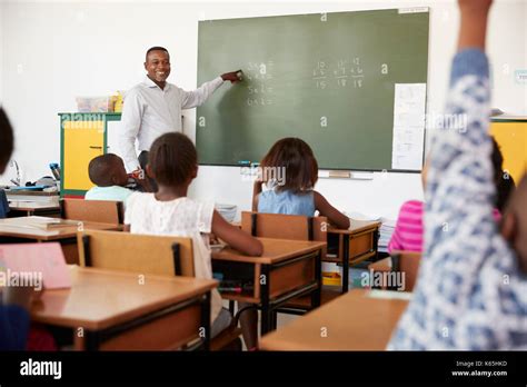 Teacher Using Chalkboard In A Lesson At An Elementary School Stock