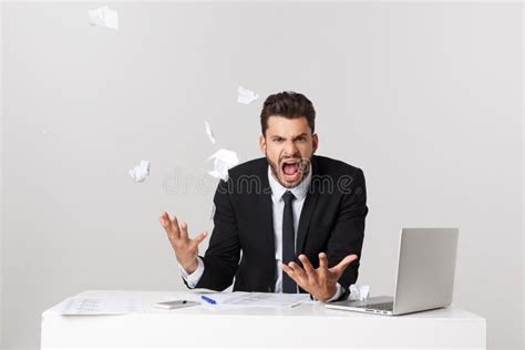 Wütende Junge Bärtige Mannarbeit am Schreibtisch Mit Dem Notebook