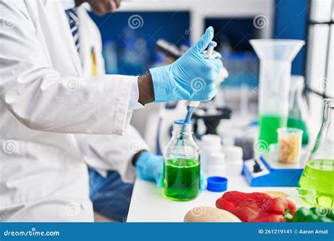 African American Man Scientist Pouring Liquid On Test Tube At