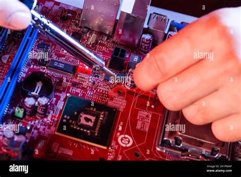 A Man Soldering A Motherboard Repair And Maintenance Of Desktop