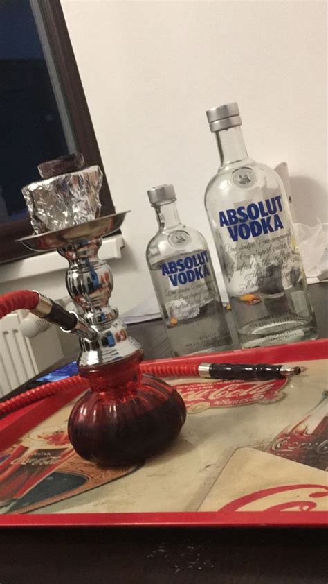 A Red Tray Topped With Two Bottles Of Vodka And A Silver Cup Sitting On