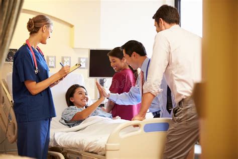 Medical Team Meeting Around Female Patient In Hospital Room Stock Image