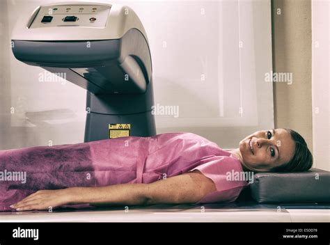 Woman In Her 40s Undergoing Scan At Bone Densitometer Machine Stock