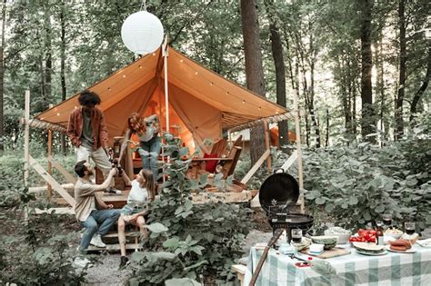 Jóvenes amigos disfrutan de una tarde soleada en el glamping forestal