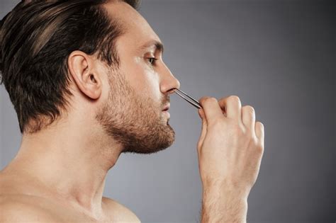 Premium Photo Side View Portrait Of A Confident Man Removing Nose Hair