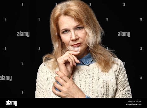 Portrait Of Thoughtful Mature Woman On Dark Background Stock Photo Alamy