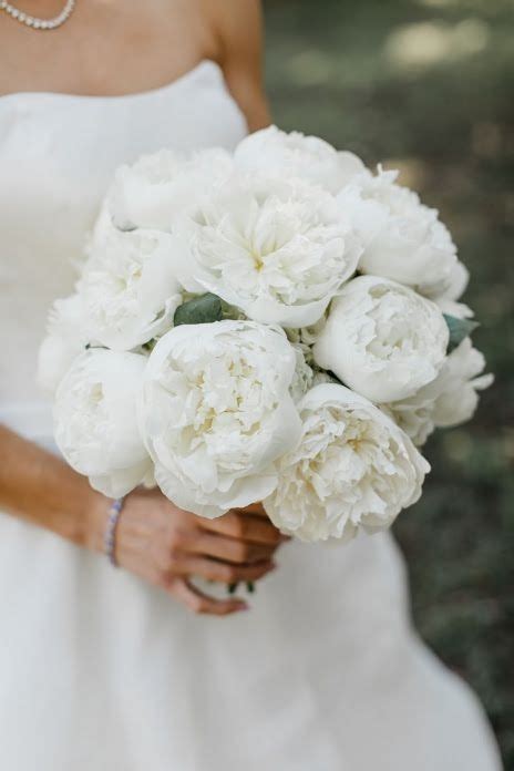 A Bride Holding A Bouquet Of White Flowers