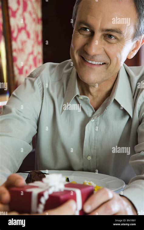 Mature Man Giving Woman Gift Cropped Stock Photo Alamy