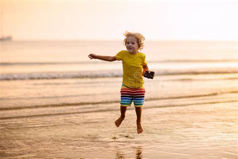 Criança Brincando Na Praia Oceânica Criança No Mar Do Pôr Do Sol Imagem