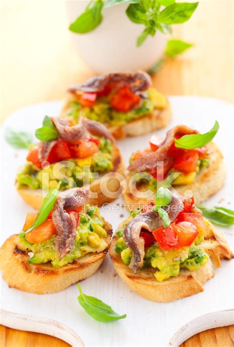 Foto De Stock Crostini Con Aguacate Tomate Y Anchoas Libre De