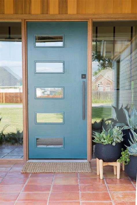 A Blue Front Door With Potted Plants On The Side