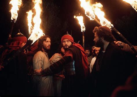 Two Men With Torches In Their Hands Standing Next To Each Other