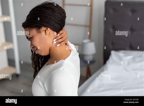 Portrait Of Black Woman With Neck Pain Sitting On Bed Stock Photo Alamy