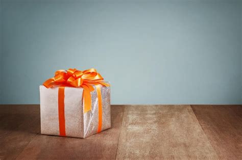 Premium Photo Gift Box With Orange Ribbons On Wooden Background