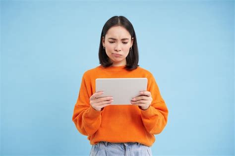 Premium Photo Upset Asian Woman Looks Sad At Digital Tablet Reads Bad News On Gadget Standing