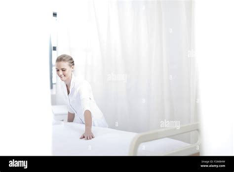 Smiling Nurse Making Hospital Bed Stock Photo Alamy